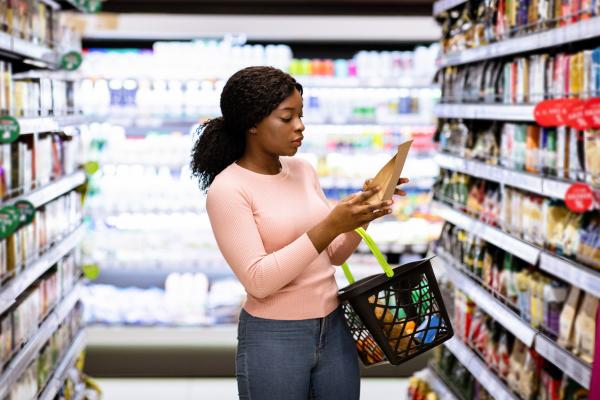Woman shopping in a grocery store and reading nutrition labels