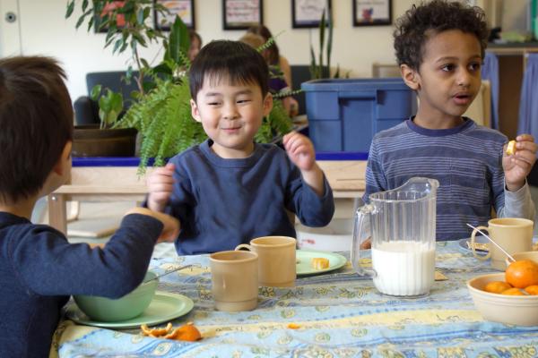 3 kids eating a snack at a table