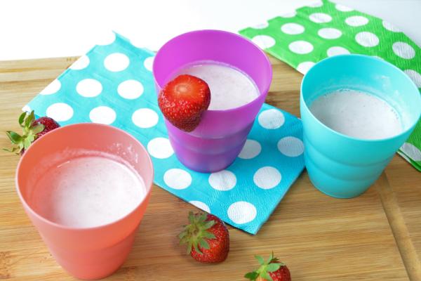 3 small colorful cups filled with a smoothie on set on blue napkins