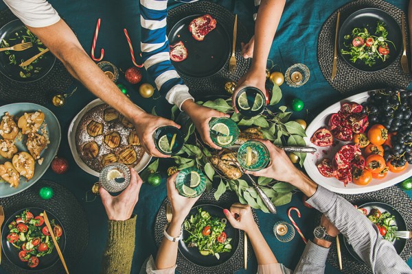 Friends and family gathering around a table to share a meal