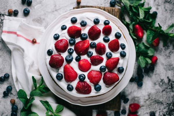 A cake topped with whipped cream and fresh berries 