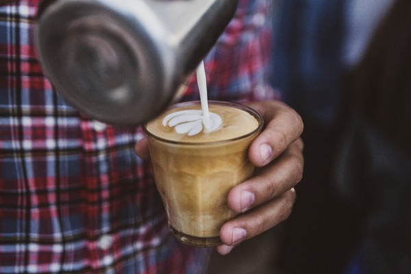 hand pouring latte