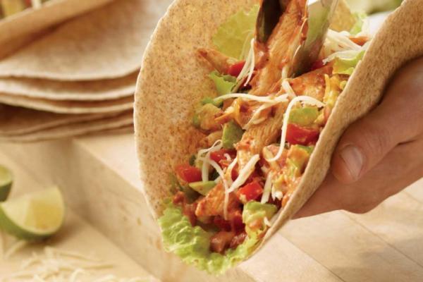 Fajitas topped with chicken, salsa, avocado and cheese