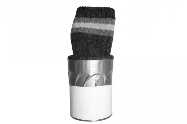 Black and white image of tin can with sock taped to the top to hide contents of can. 
