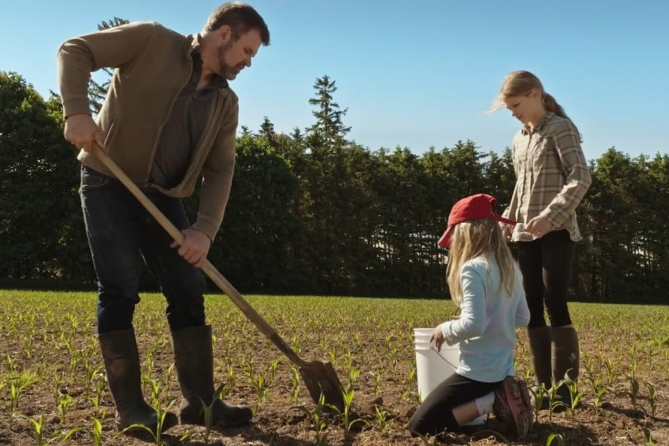 Dairy farmer and family in field