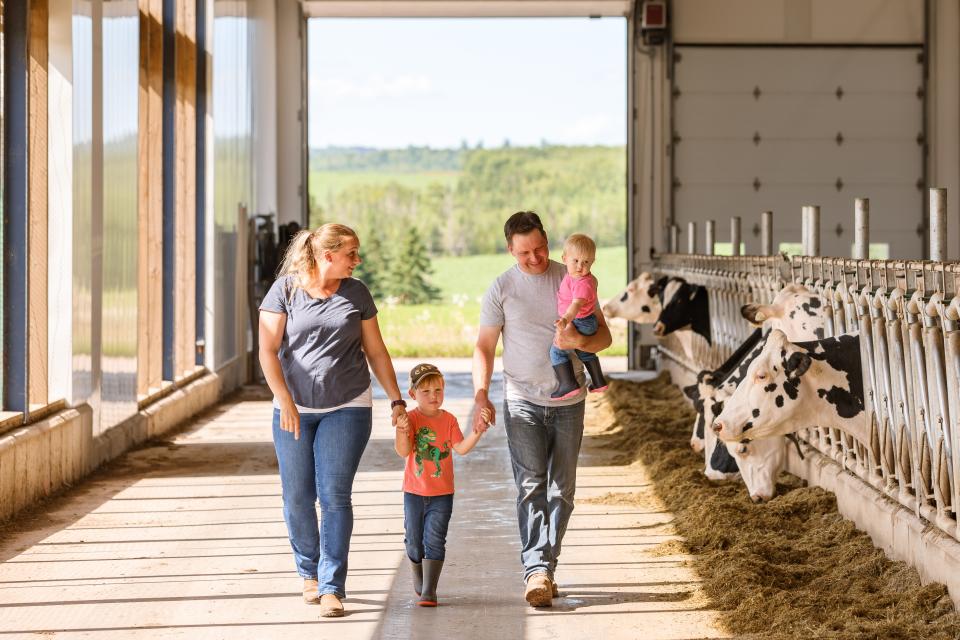 A farming family walks through their barn