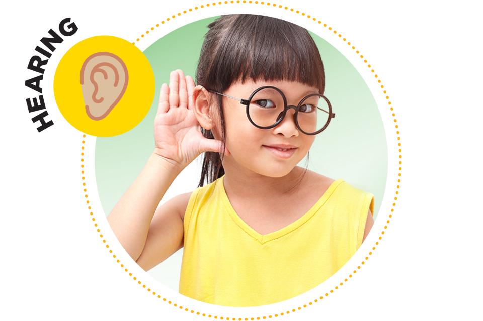 Little girl holding her hand to her ear.