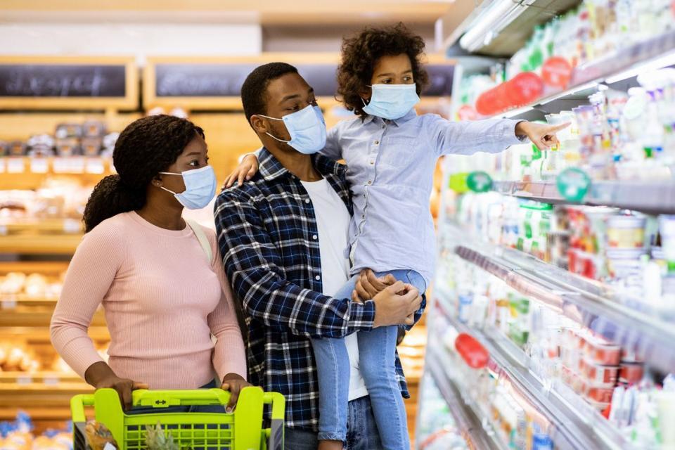 A Black man and woman grocery shop with their young child
