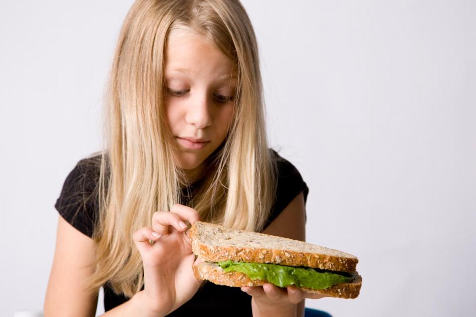 Young girl who does not want to eat her sandwich