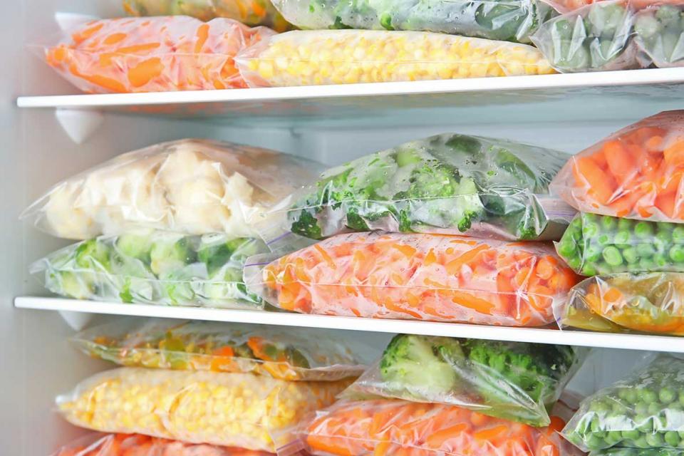 Bags of frozen vegetables in freezer.