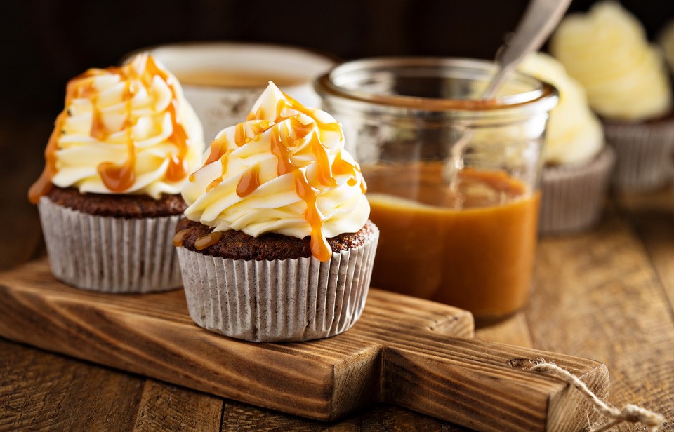 Petits gâteaux garnis de crème fouettée et de sauce au caramel