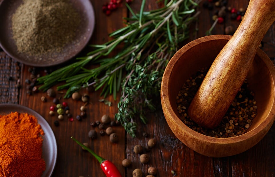 Spices being ground up in mortar and pestle. 