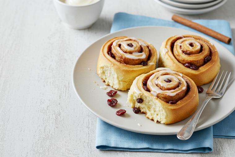 Three biscuit cinnamon rolls with dried cranberries on a plate