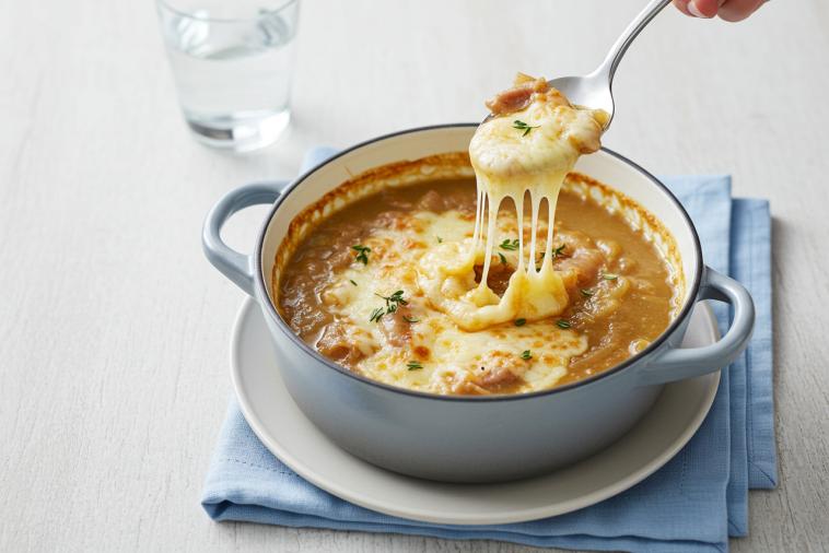 Creamy French onion soup topped with broiled melted cheese in a bowl