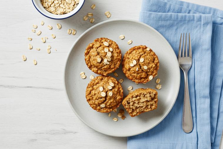 Top-down image of three banana raisin oat bran muffins on a plate