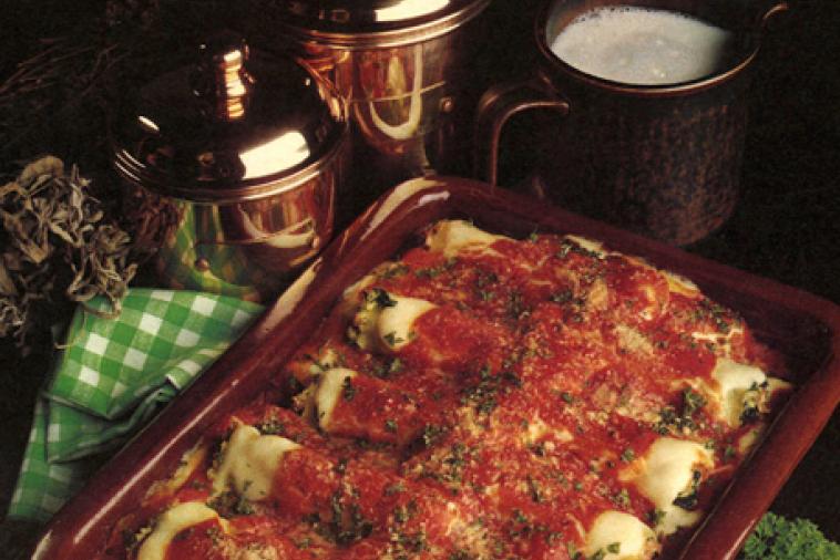Casserole dish of Cannelloni covered in a tomato sauce