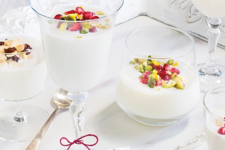 Three milk puddings topped with berries and nuts