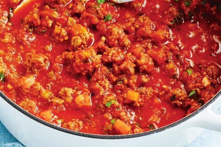 Bowl of creamy Canadian spaghetti sauce with ground beef and vegetables