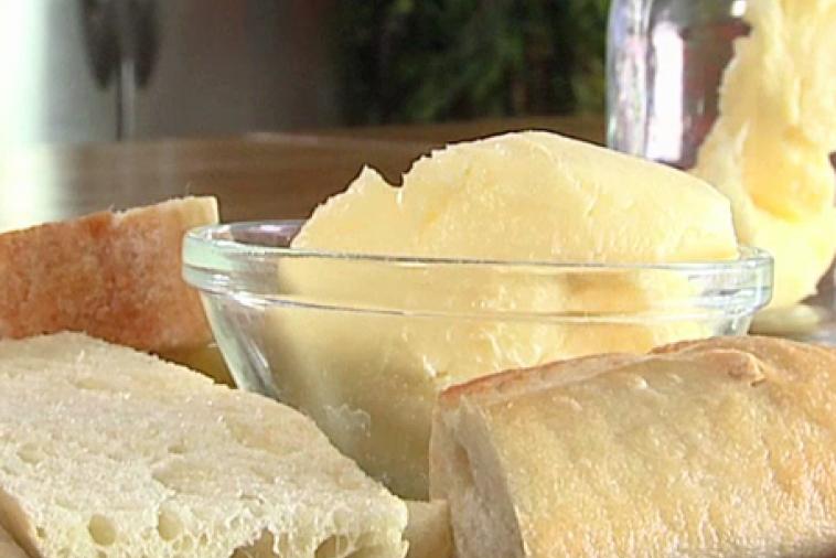 Glass bowl of homemade butter served with fresh bread