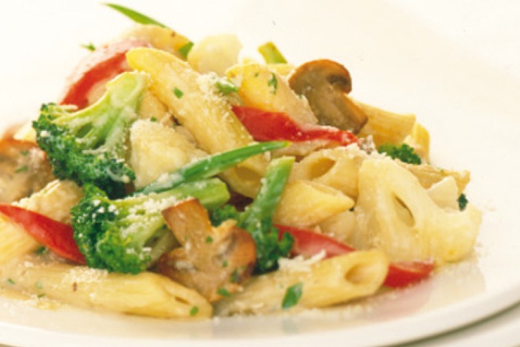 A plate of broccoli cauliflower pasta sprinkled with grated cheese, showcasing a mix of penne, fresh green broccoli florets, cauliflower, and slices of red bell pepper.